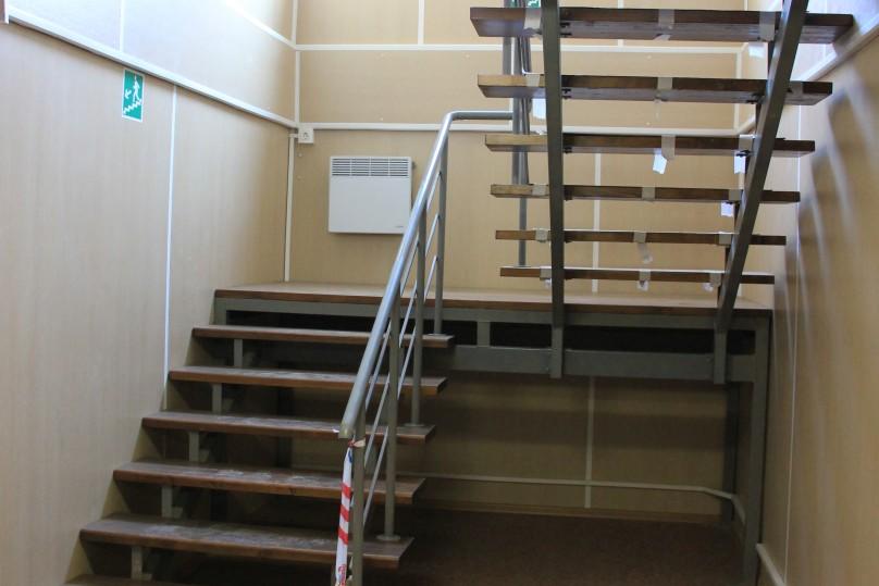 A staircase with wooden steps and handrails of a circular tube